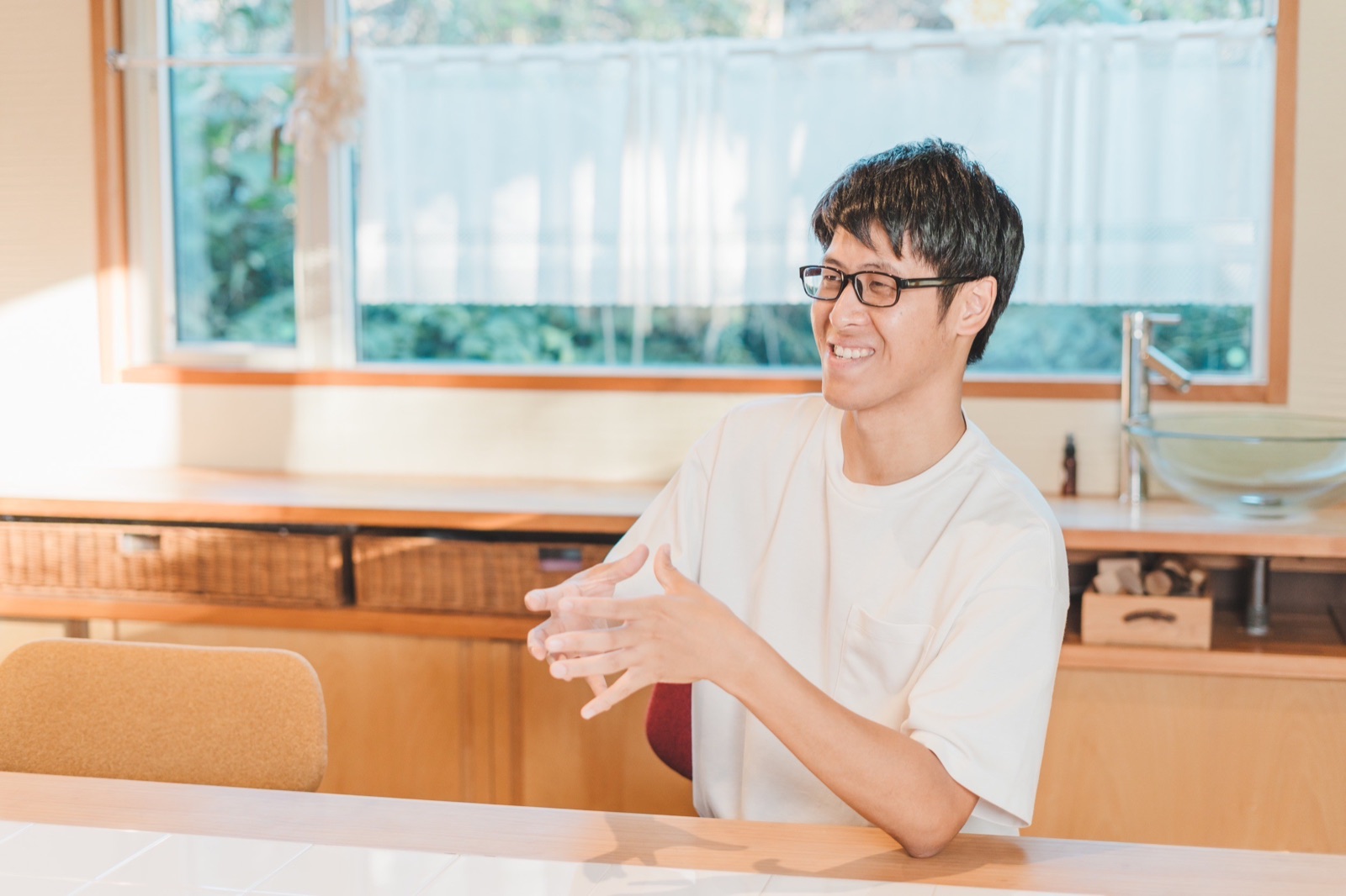 手を組んで笑顔で話すあべさん