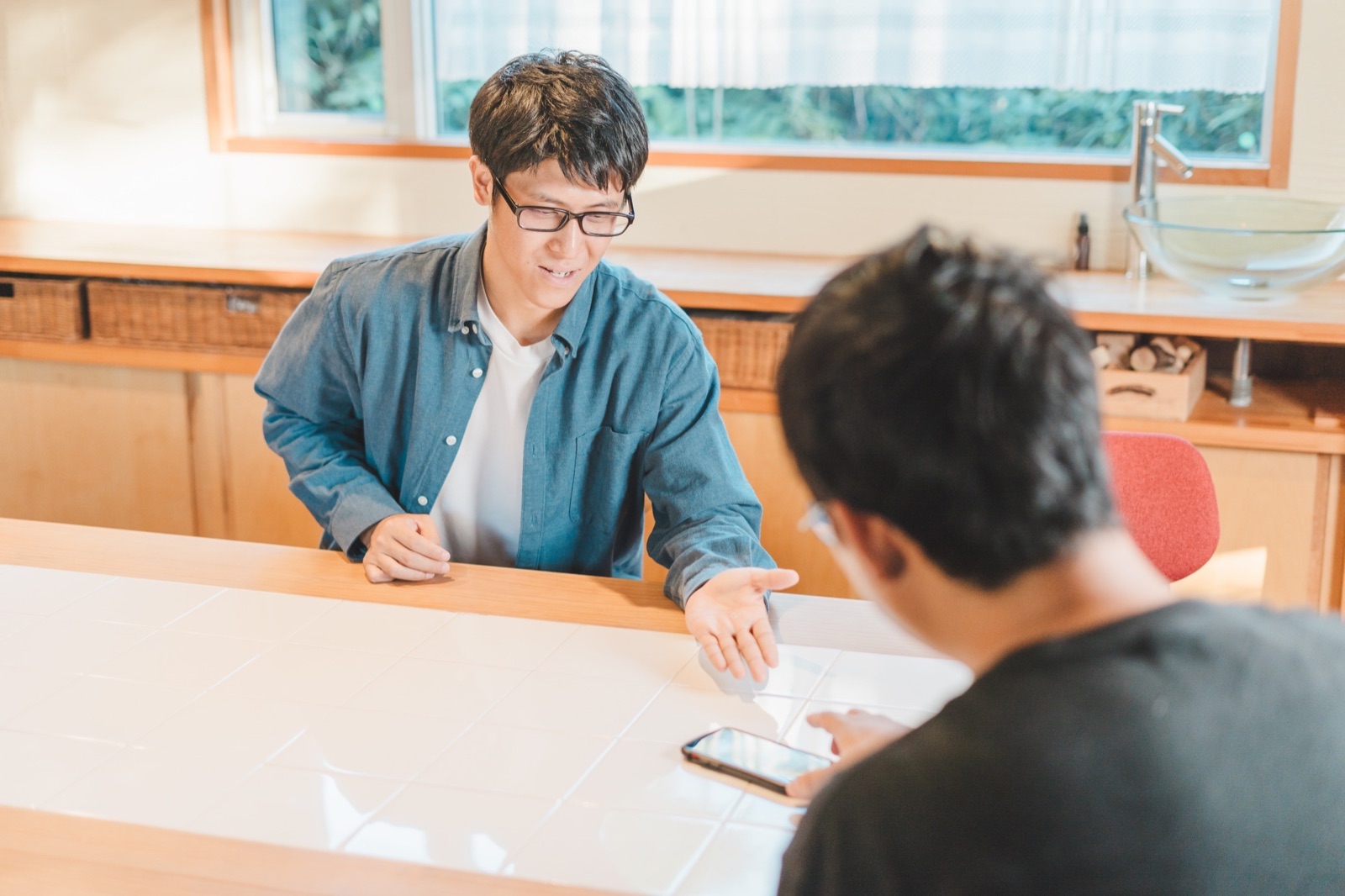 スマホを示しながら見積もりを説明するあべさん